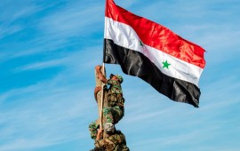 Syrian government soldiers climb up a wooden pole with a Syrian government national flag while deploying for the first time in the eastern countryside of the city of Qamishli in the northeastern Hasakah province on November 5, 2019.