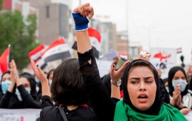 An Iraqi woman raises her fist as she takes part in an anti-government march in the center of the southern city of Basra on December 2, 2019.