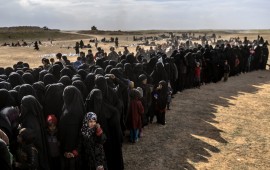 Civilians evacuated from the Islamic State (IS) group's embattled holdout of Baghouz wait for bread and water at a screening area held by the Kurdish-led Syrian Democratic Forces (SDF), in the eastern Syrian province of Deir Ezzor, on March 5, 2019. - More than 7,000 people, mostly women and children, have fled the shrinking pocket over the past two days, as US-backed forces press ahead with an offensive to crush holdout jihadists. (Photo by Bulent KILIC / AFP) (Photo credit should read BULENT KILIC/AFP via