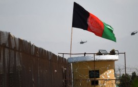 Two US military helicopters are seen flying past an Afghan national flag during the 100th anniversary of the country's Independence Day in Kabul on August 19, 2019. 