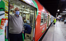 Man wearing a face mask stands in the doorway of public transportation