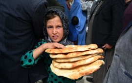 Young Afghan girl holding bread. 