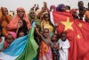 People hold Chinese and Djiboutian national flags as they wait for the arrival of Djibouti's President Ismail Omar Guellehas before the launching ceremony of new 1000-unit housing contruction project in Djibouti, on July 4, 2018. - The new 1000-unit construction project by the Ismail Omar Guelleh Foundation for Housing is financially supported by China Merchant, the operation parther of newly inaugurated Djibouti International Free Trade Zone (DITTZ) with Djibouti Ports and Free Zones Authority, to build ba