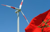 A Moroccan flag flies next to a wind turbine on June 28, 2010, at a wind farm near Tangiers shortly after its inauguration by Moroccan King Mohammed VI. Photo by ABDELHAK SENNA/AFP via Getty Images.