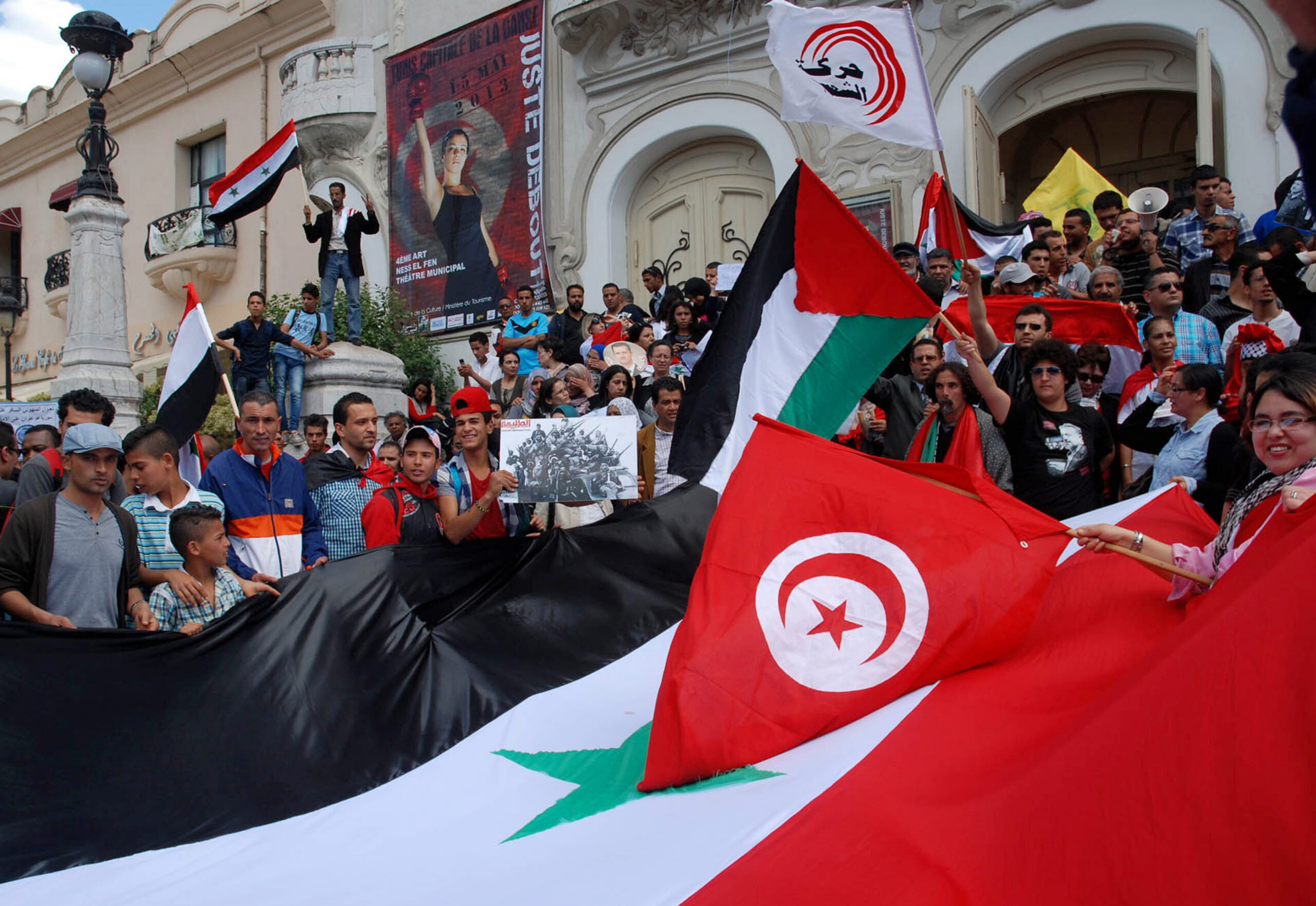 Tunisian protestors wave their national and the Syrian flags on May 6, 2013. 