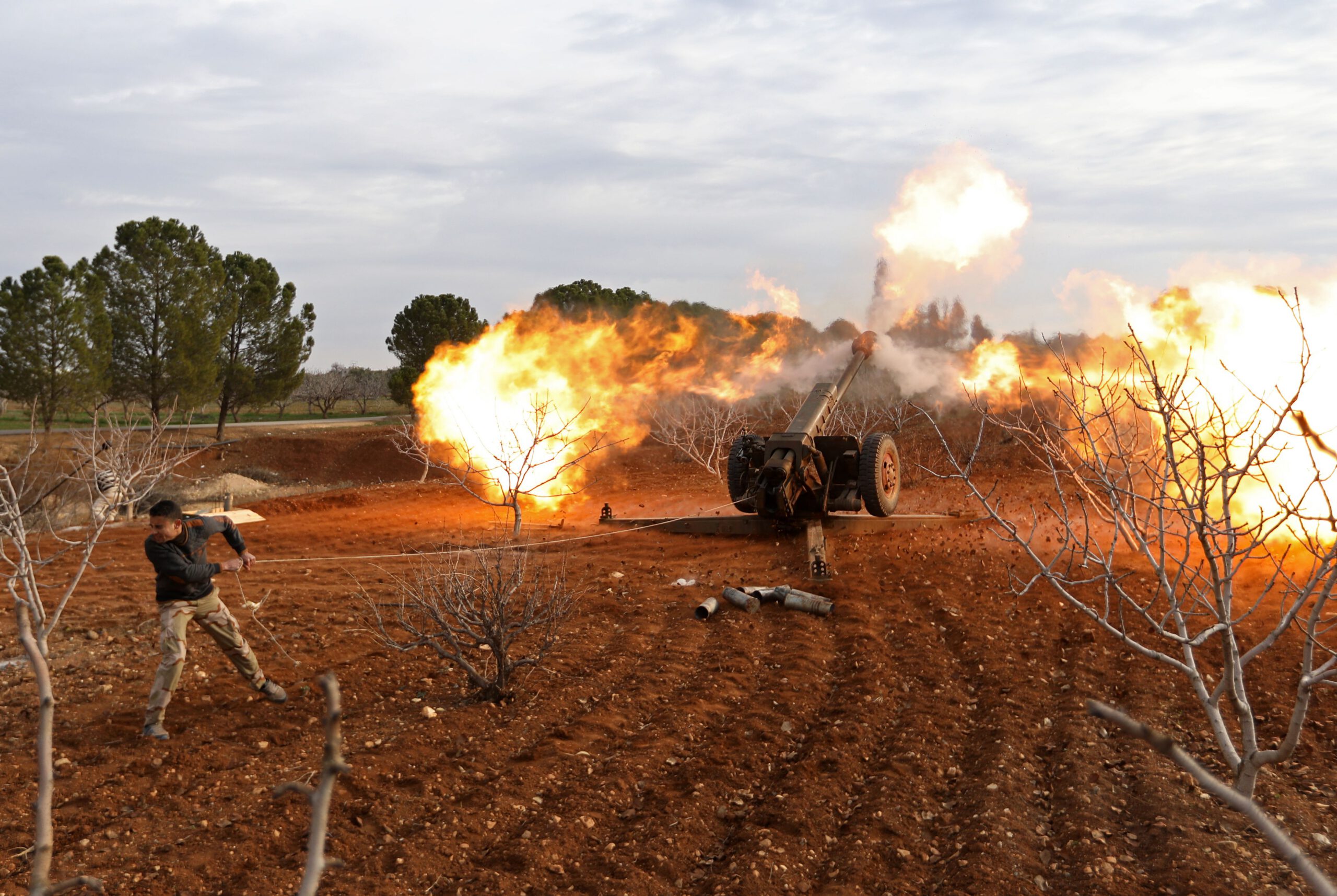 An opposition fighter fires a gun from a village near al-Tamanah during ongoing battles with government forces in Syria's Idlib province on January 11, 2018