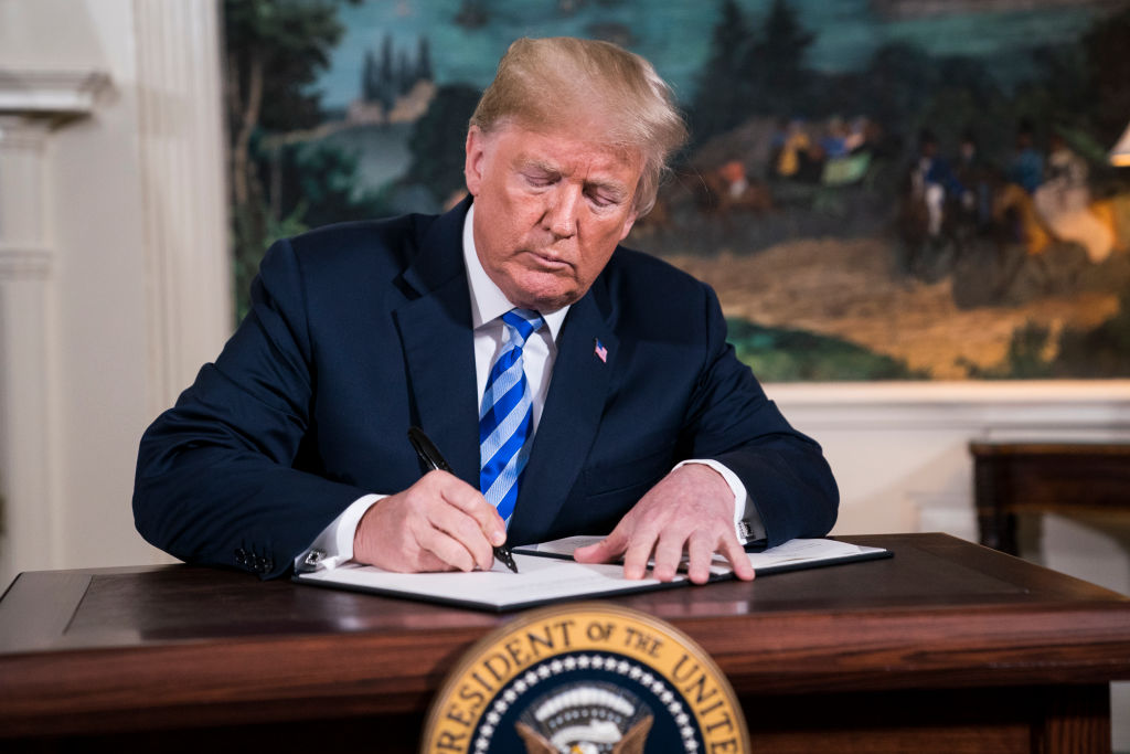 President Donald J. Trump signs a National Security Presidential Memorandum as he announces the withdrawal of the United States from the Iran nuclear deal during a 'Joint Comprehensive Plan of Action' event in the Diplomatic Reception Room of the White House on Tuesday, May 08, 2018 in Washington, DC.