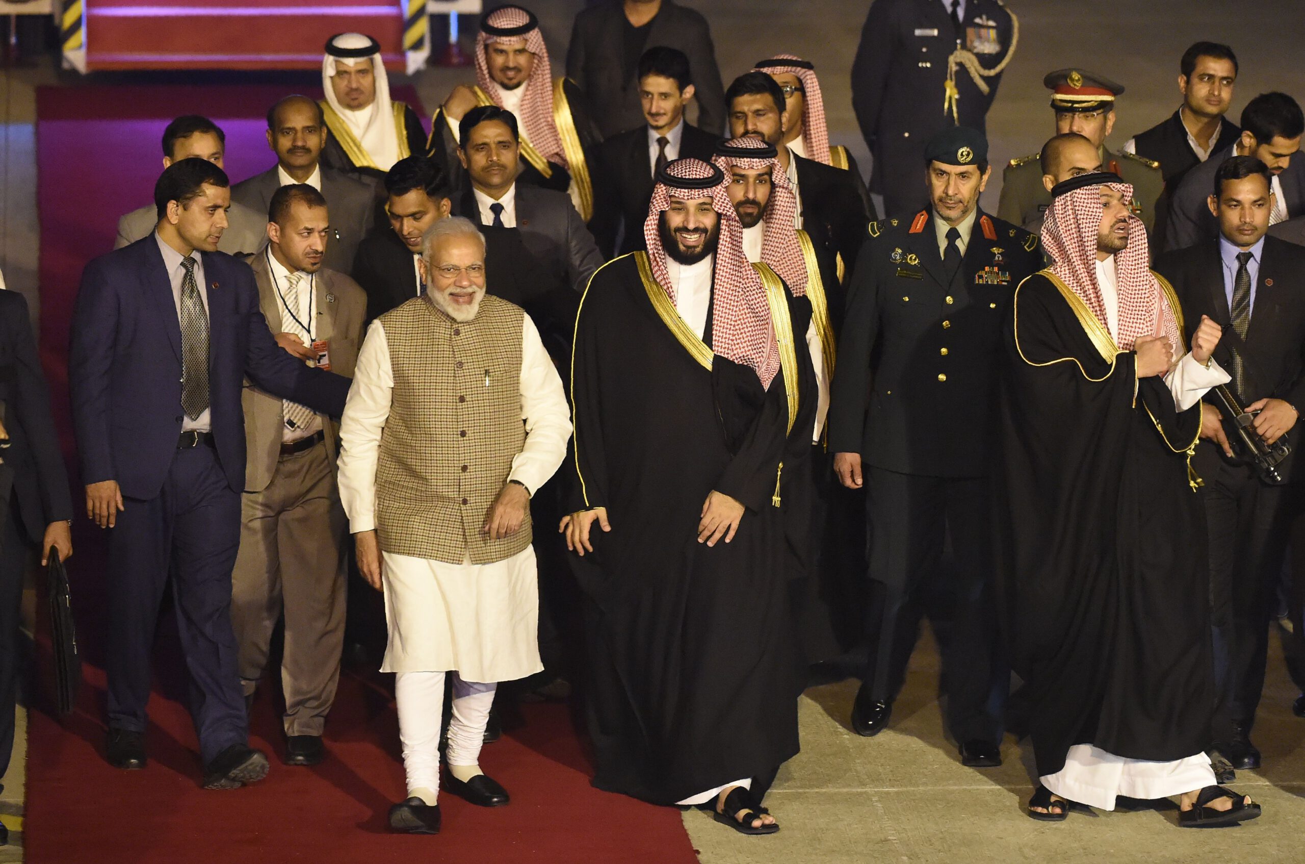 Saudi Crown Prince Mohammed bin Salman walks next to Indian Prime Minister Narendra Modi upon arriving at the airport in New Delhi on February 19, 2019.