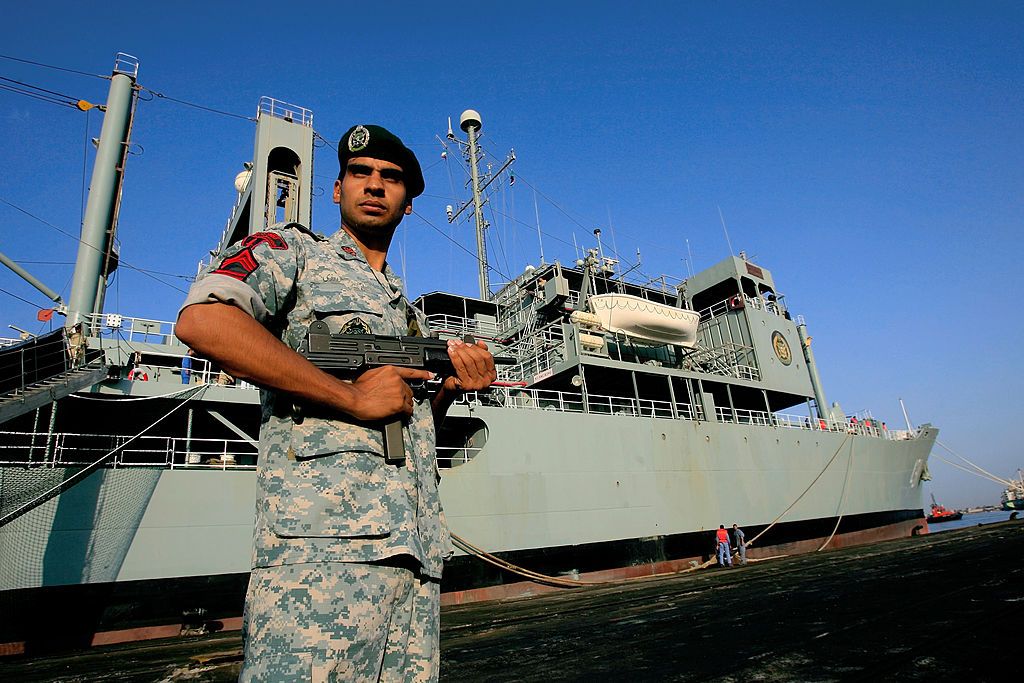 An Iranian navy special forces known as Takavaran wearing a similar uniform worn by the US military and holding an Israeli made Uzi sub-machine gun stands guard near the Iranian Kharg replenishment ship docked in the Red Sea Sudanese town of Port Sudan on October 31, 2012. 