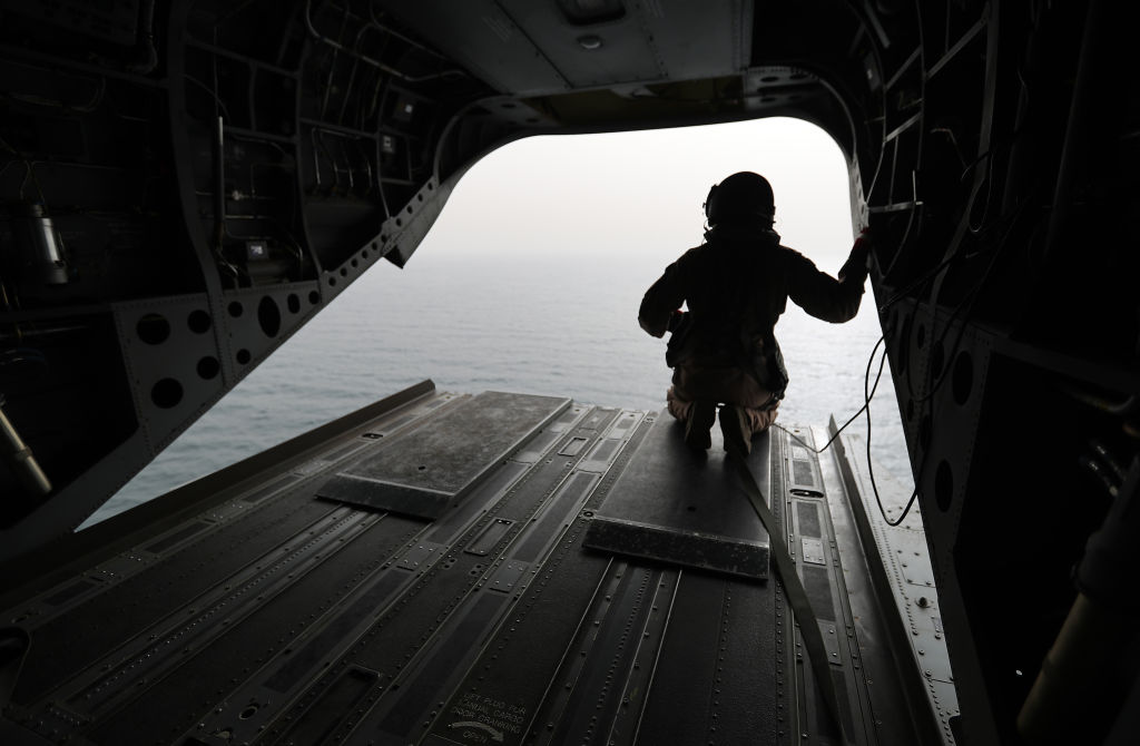 August 2018: An Emirati soldier watching from a military plane a ship crossing through the strategic strait of Bab al-Mandab