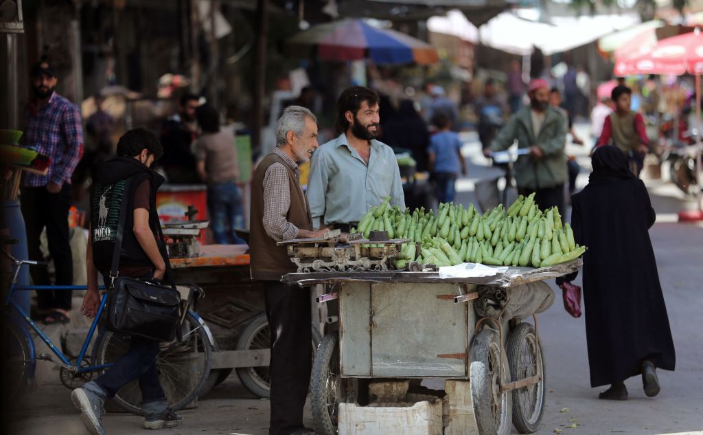 A Syrian man stands by a vegetable stall in an open-air market in the rebel-held town of Douma, on the eastern outskirts of Damascus on May 23, 2017.