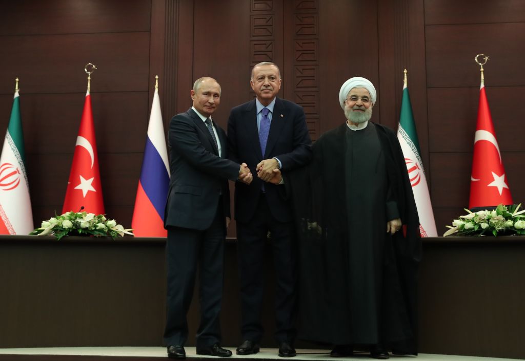 President of Turkey Recep Tayyip Erdogan (C), President of Russia Vladimir Putin (L) and President of Iran Hassan Rouhani (R) shake hands as they pose for a photo after a joint press conference following the Turkey-Russia-Iran trilateral summit at Cankaya Mansion in Ankara, Turkey on September 16, 2019. 