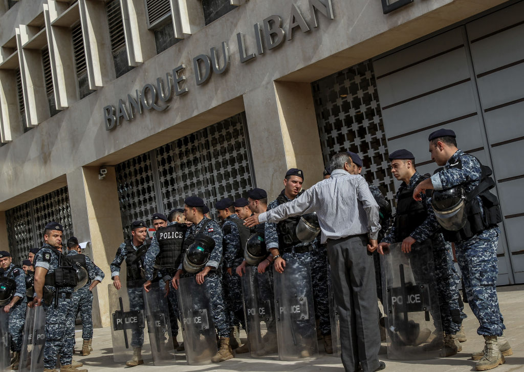 A demonstrator argues with riot police guarding the entrance of the Lebanese Central Bank during a protest by retired Lebanese army and security personnel as part of a preemptive strike against austerity measures in the 2019 draft state budget that might affect their retirement wages. 