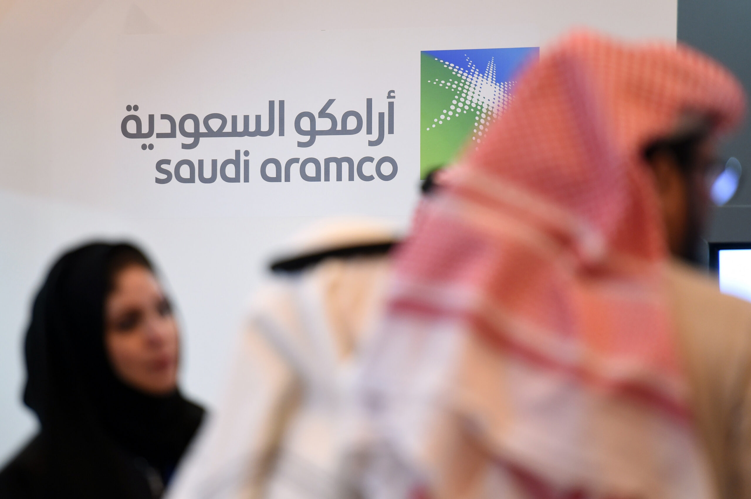 Saudi and Foreign investors stand in front of the logo of Saudi state oil giant Aramco during the 10th Global Competitiveness Forum on January 25, 2016, in the capital Riyadh. The an annual event brings together high-ranking Saudi officials and world business leaders. / AFP / Fayez Nureldine (Photo credit should read FAYEZ NURELDINE/AFP/Getty Images)