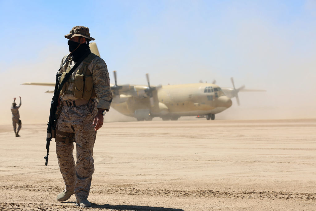 Saudi soldiers stand guard as a Saudi air force cargo plane, carrying aid, lands at an airfield in Yemen's central province of Marib, on February 8, 2018.