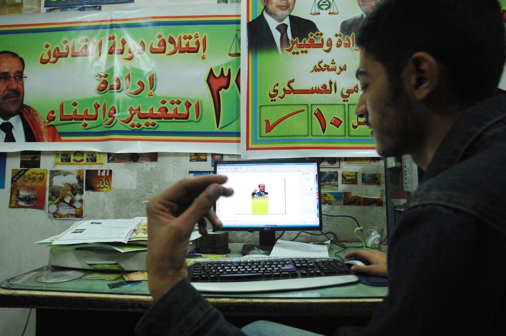 BAGHDAD, IRAQ - FEBRUARY 3: An Iraqi print house worker discusses the design of a campaign leaflet with a candidate's staff while they work the graphics on an office computer February 3, 2010 in Baghdad, Iraq. Print house workers have been laboring three shifts a day to keep up with demands for campaign posters as Iraq prepares for the upcoming March 7th national elections. More than 6,000 candidates are contesting a vote that will be critical to the future of Iraq, seven years after a US invasion toppled d
