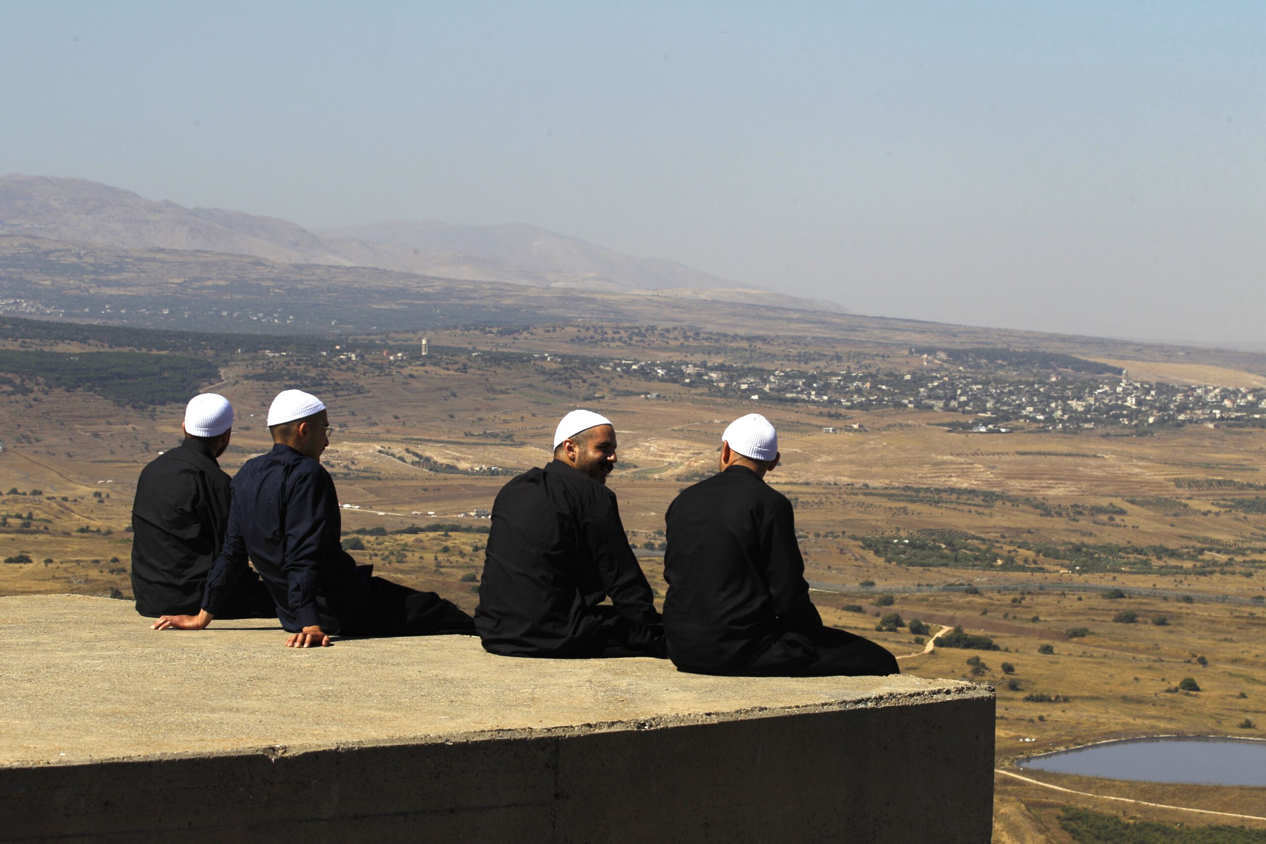 Cover photo: Druze men in the Israeli-annexed Golan Heights look out across the southwestern Syrian province of Quneitra, visible across the border on July 7, 2018. (Photo by JALAA MAREY/AFP/Getty Images)