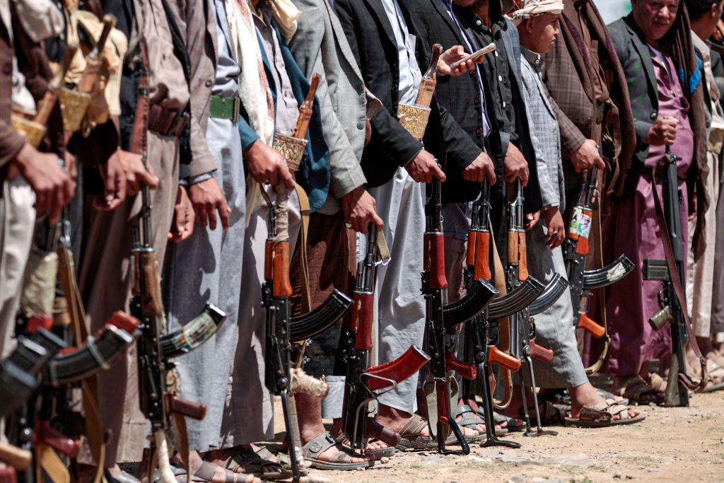 Yemeni men stand with Kalashikov assault rifles during a tribal meeting in the Huthi rebel-held capital Sanaa on September 21, 2019, as tribesmen donate rations and funds to fighters loyal to the Houthis along the fronts. 