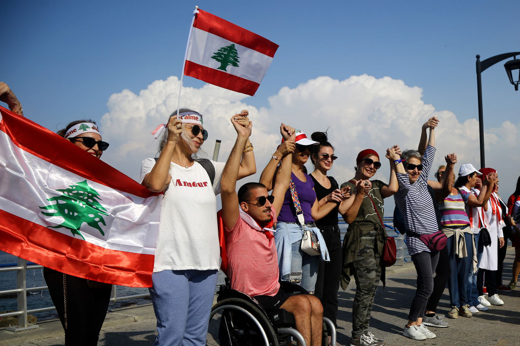 Lebanese people hold hands as they form a human chain, that stretched out along the coast from the capital Beirut to northern and southern Lebanon, symbolizing national unity, on the 11th day of anti-government protests across Lebanon. 