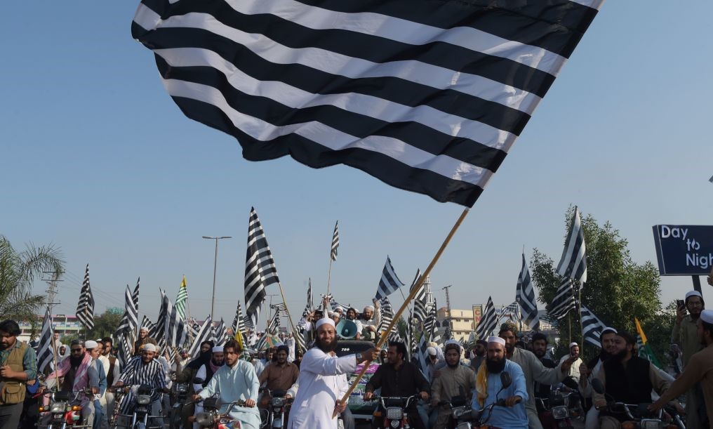 An activists of the Jamiat Ulema-e-Islam waves the party flag during the anti-government 
