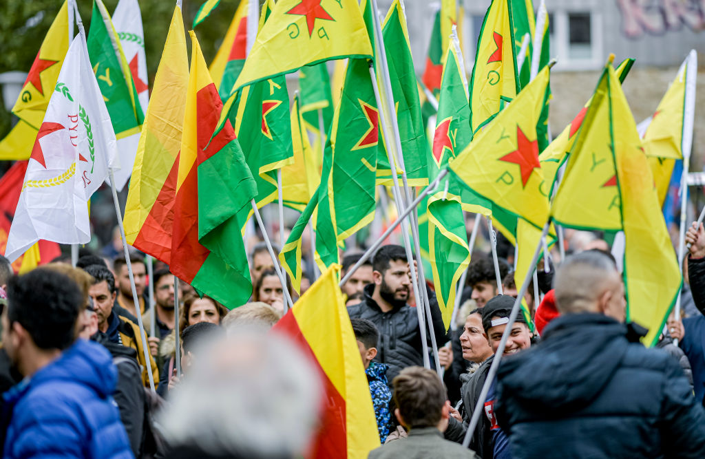 12 October 2019, Hamburg: Participants of a Kurdish demonstration waving flags of the YPG.