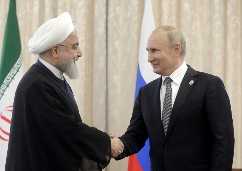 Iran's President Hassan Rouhani (L) and Russia's President Vladimir Putin shake hands as they meet on the sidelines of a meeting of the Shanghai Cooperation Organisation (SCO) Council of Heads of State.
