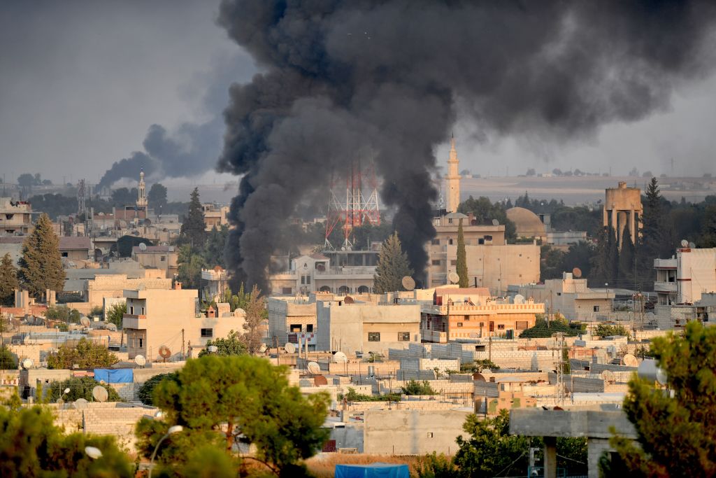 A photo taken from Turkey's Sanliurfa province, on October 09, 2019 shows smoke rises at the site of Ras al-Ayn city of Syria as Turkish troops along with the Syrian National Army begin Operation Peace Spring in northern Syria against PKK/YPG, Daesh terrorists. 
