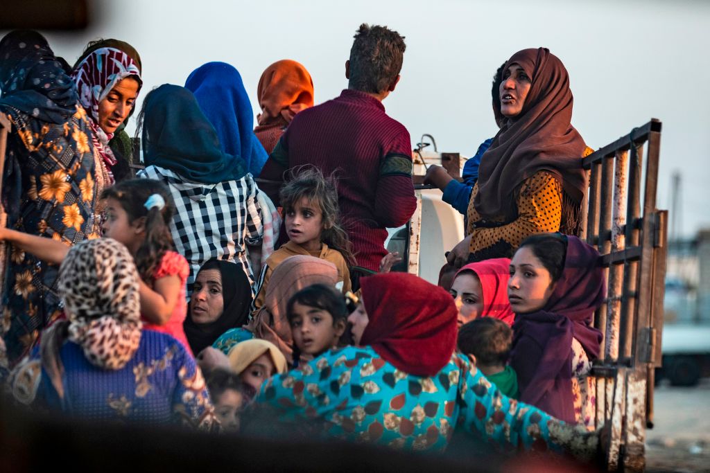  Syrian Arab and Kurdish civilians flee amid Turkish bombardment on Syria's northeastern town of Ras al-Ain in the Hasakeh province along the Turkish border on October 9, 2019.