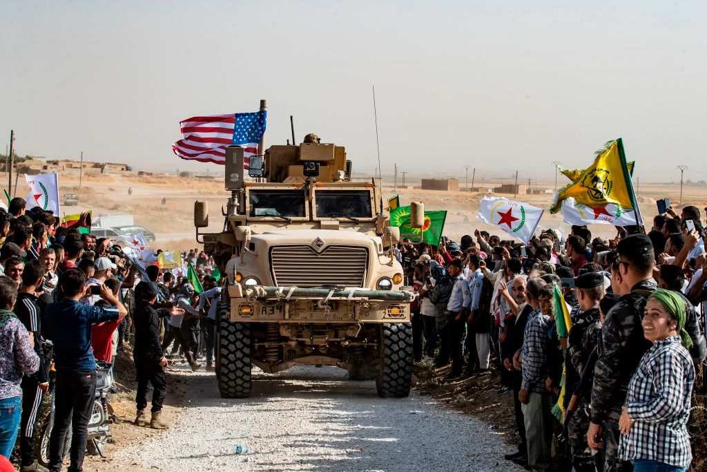  Syrian Kurds gather around a US armoured vehicle during a demonstration against Turkish threats next to a US-led international coalition base on the outskirts of Ras al-Ain town in Syria's Hasakeh province near the Turkish border on October 6, 2019. 