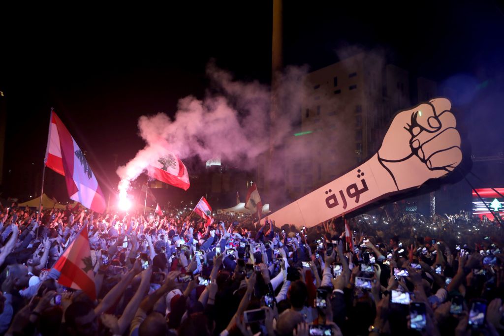 Lebanese demonstrators raise a new giant sign of a fist that bears the Arabic word 