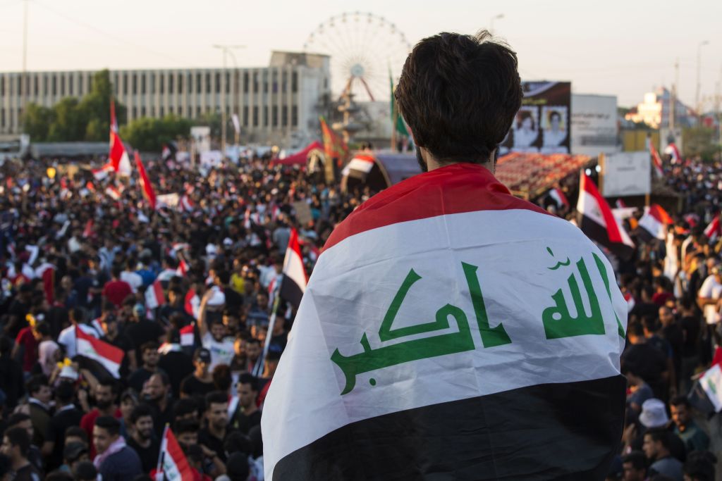 An Iraqi protester deaped in his national flag takes part in an anti-government protest in the southern city of Basra on November 1, 2019.