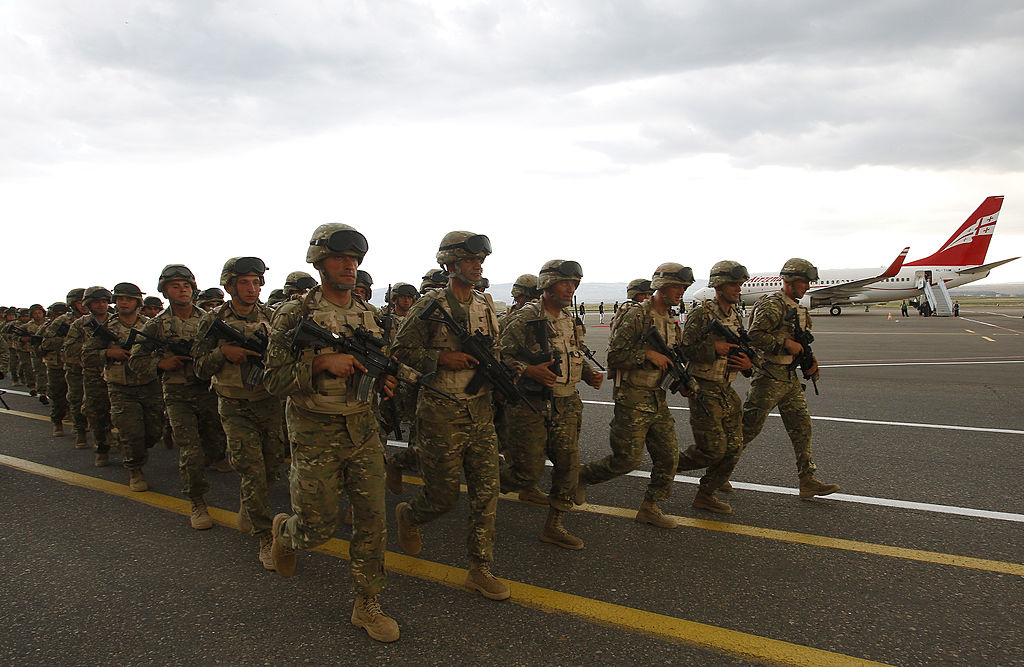 Georgian soldiers run during a farewell ceremony before their departure to Afghanistan in Tbilisi, June 27, 2013. 