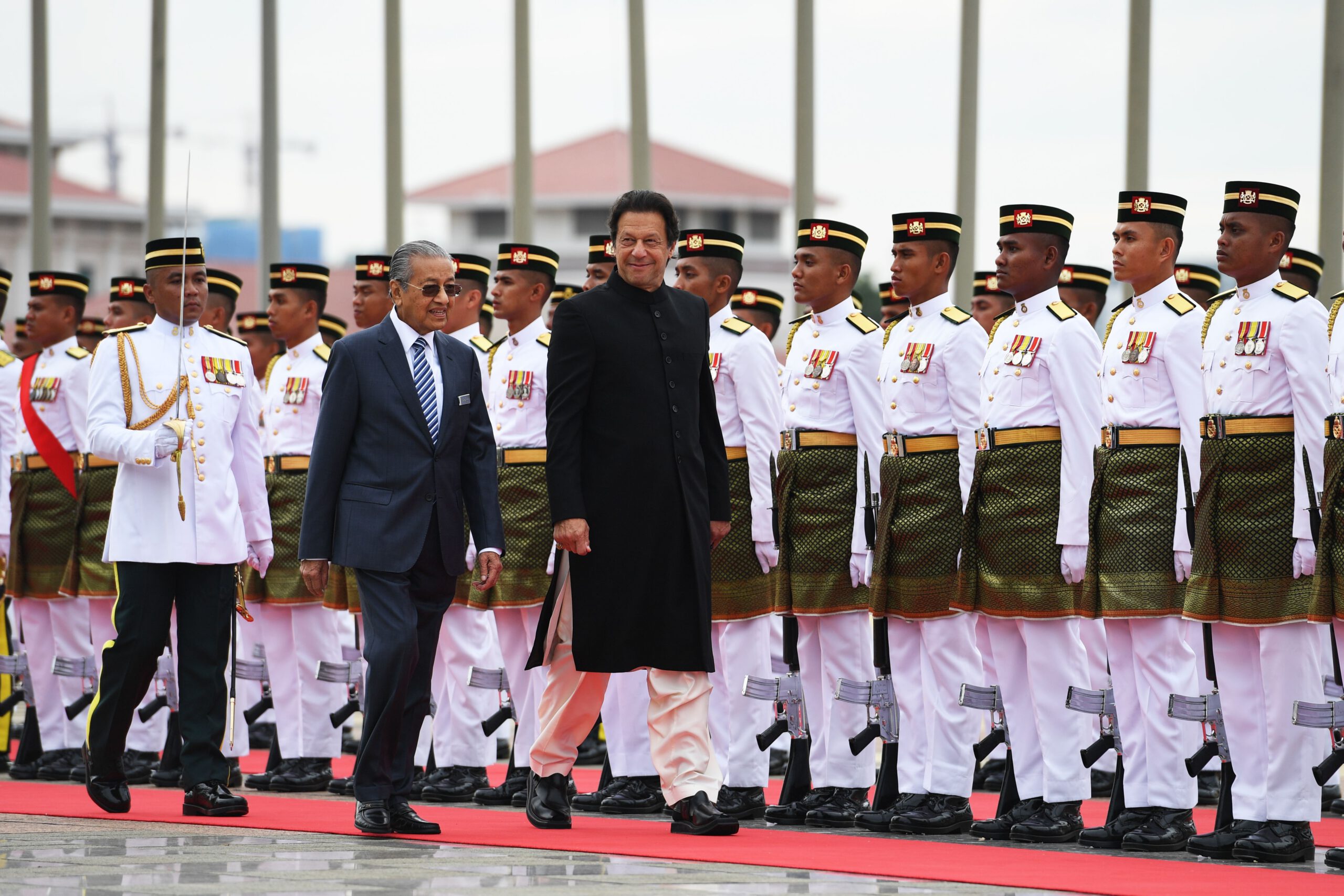 Pakistan's Prime Minister Imran Khan (C) is accompanied by his Malaysian counterpart Mahathir Mohamad (L) as he reviews a guard of honour during a welcoming ceremony at the prime minister's office in Putrajaya on November 21, 2018. (Photo by Mohd RASFAN / AFP) (Photo credit should read MOHD RASFAN/AFP via Getty Images)