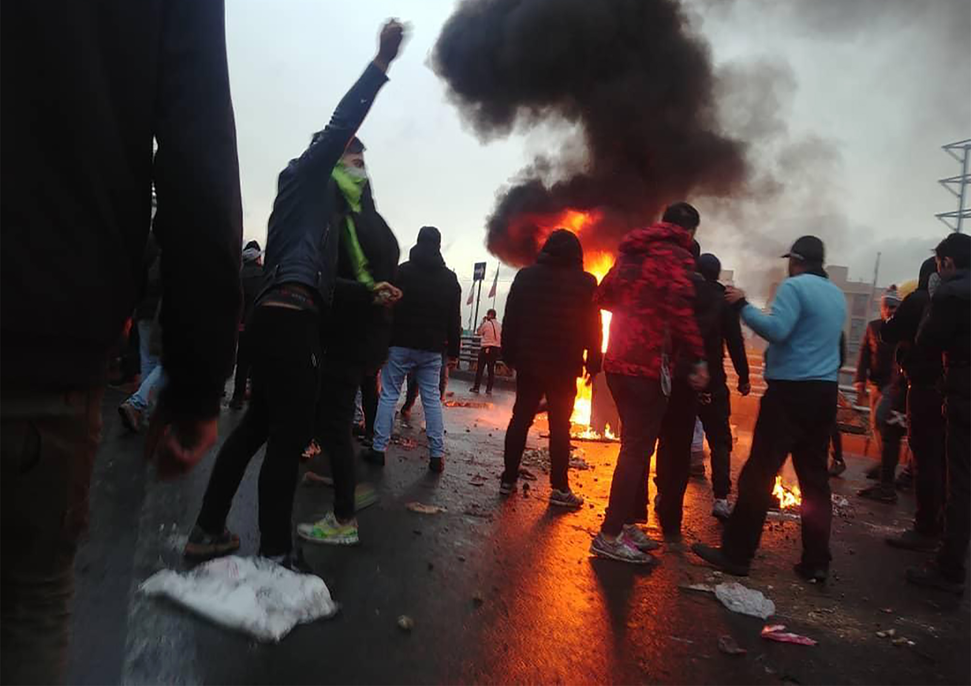 Iranian protesters gather around a fire during a demonstration against an increase in gasoline prices in the capital Tehran, on November 16, 2019. - One person was killed and others injured in protests across Iran, hours after a surprise decision to increase petrol prices by 50 percent for the first 60 litres and 300 percent for anything above that each month, and impose rationing. Authorities said the move was aimed at helping needy citizens, and expected to generate 300 trillion rials ($2.55 billion) per 