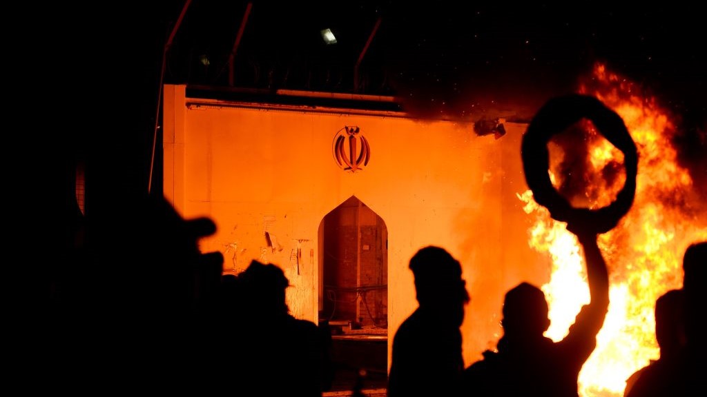 Iraqi demonstrators gather as flames start consuming Iran's consulate in the southern Iraqi Shiite holy city of Najaf on November 27, 2019, two months into the country's most serious social crisis in decades.