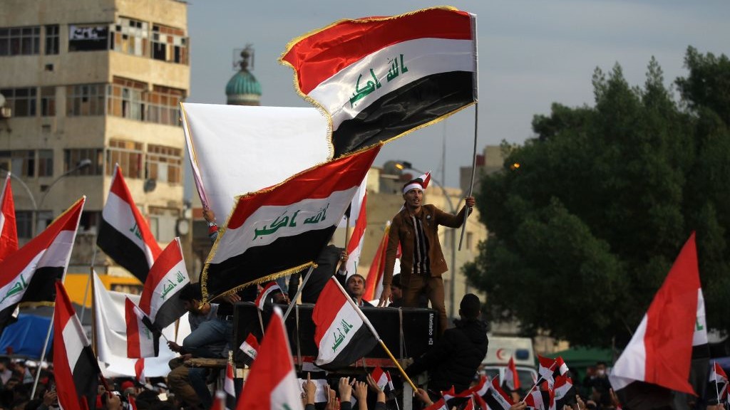 Iraqi demonstrators wave national flags as they take part in an anti-government demonstration in the capital Baghdad's Tahrir Square, on December 6, 2019. 