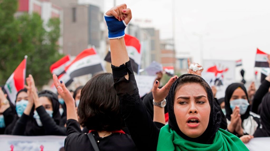 An Iraqi woman raises her fist as she takes part in an anti-government march in the center of the southern city of Basra on December 2, 2019.