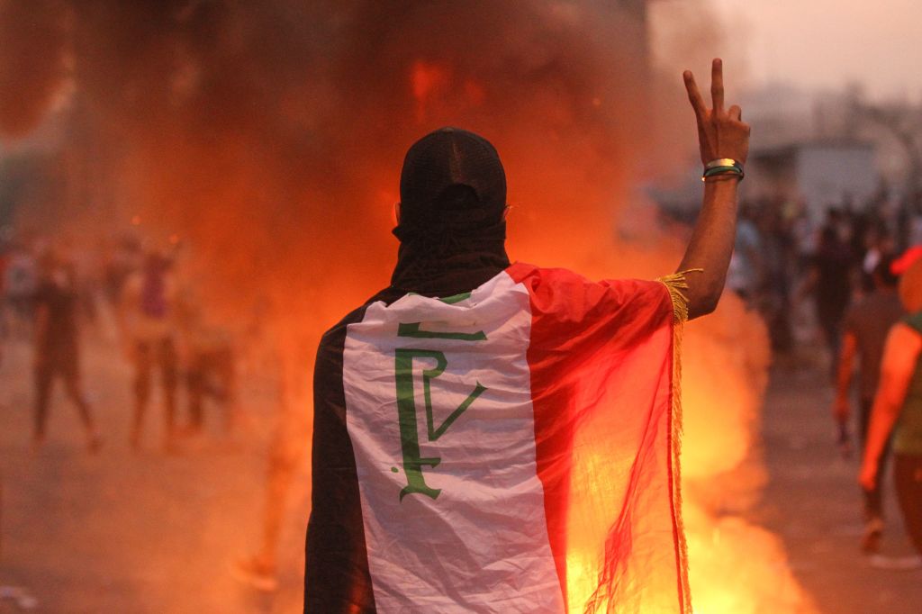 An Iraqi protester gestures the v-sign during a demonstration against state corruption, failing public services and unemployment at Tayaran square in Baghdad on October 2, 2019. 