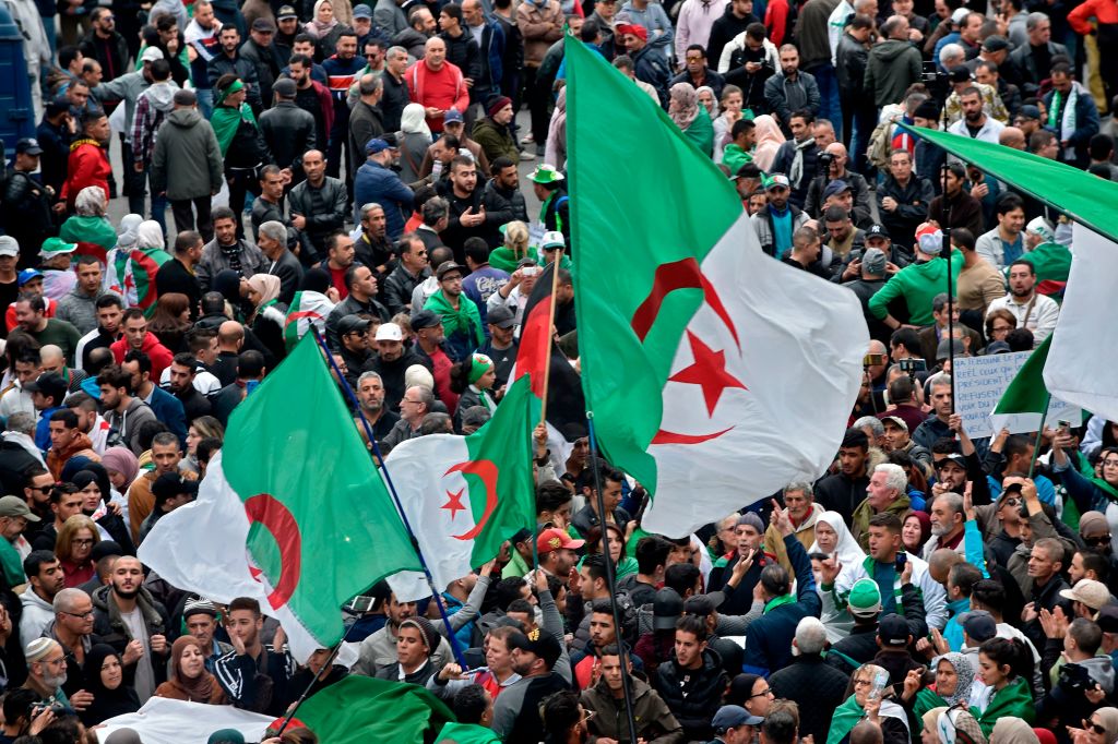 Algerian protesters wave national flags during an anti-government demonstration in the capital Algiers, on December 20, 2019. 