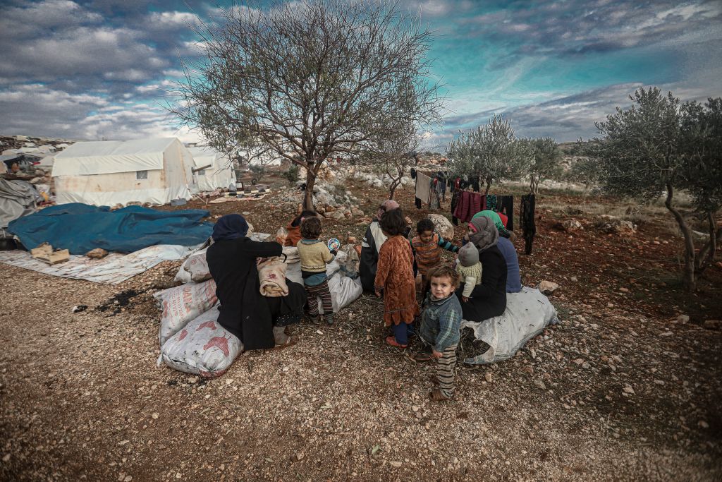 Syrian families, who have been forced to displace despite attacks carried out by Assad regime and Russia, sit on soil field despite the cold weather during winter season at Harbanush village in Idlib, Syria on December 28, 2019. 