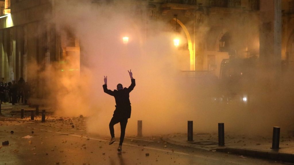 A Lebanese protester gestures at riot police guarding a road leading to parliament in central Beirut on January 19, 2020 amid ongoing anti-government demonstrations. (Photo by PATRICK BAZ / AFP) (Photo by PATRICK BAZ/AFP via Getty Images)