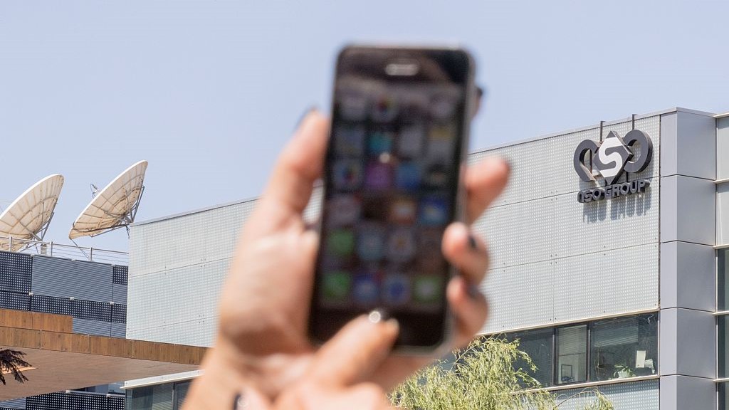 An Israeli woman uses her iPhone in front of the building housing the Israeli NSO group, on August 28, 2016, in Herzliya, near Tel Aviv. 