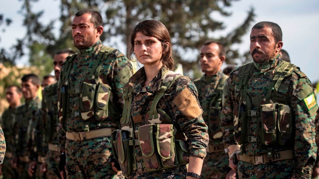 Fighters of the US-backed Kurdish-led Syrian Democratic Forces (SDF) take part in a parade to celebrate near the Omar oil field in the eastern Syrian Deir Ezzor province on March 23, 2019, after announcing the total elimination of the Islamic State (IS) group's last bastion in eastern Syria. 