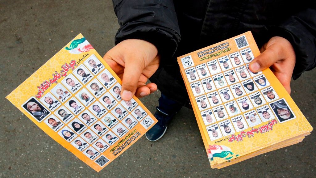 A man standing outside a mosque in the Iranian capital Tehran on February 14, 2020 hands out electoral leaflets showing candidates campaigning in the upcoming Iranian legislative election due to take place on February 21. (Photo by -/AFP via Getty Images)