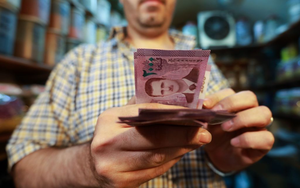 A merchant counts Syrian pound notes, bearing a portrait of the Syrian President Bashar al-Assad, at the Bzourieh market in the centre of the Syrian capital Damascus on September 11, 2019. 