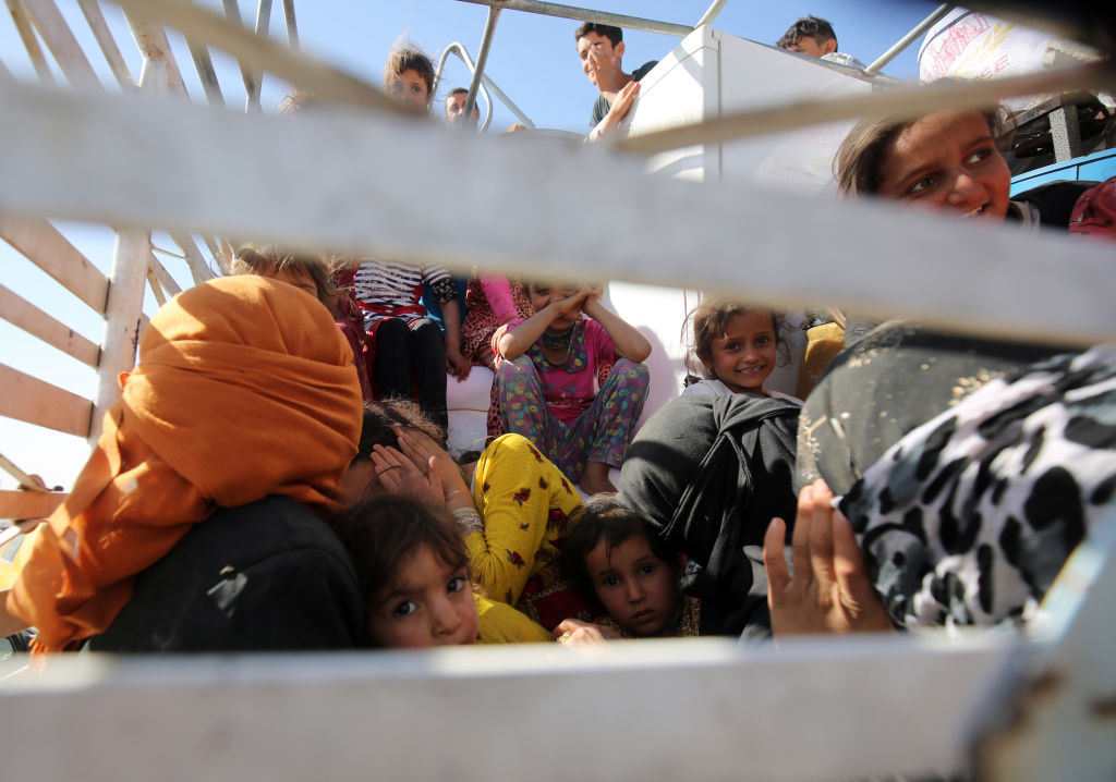 A picture taken on October 18, 2017 shows displaced Iraqis, who fled from Hawija in 2014 to Kirkuk, riding in vehicles as they return to Hawija, after the town was retaken by Iraqi forces.