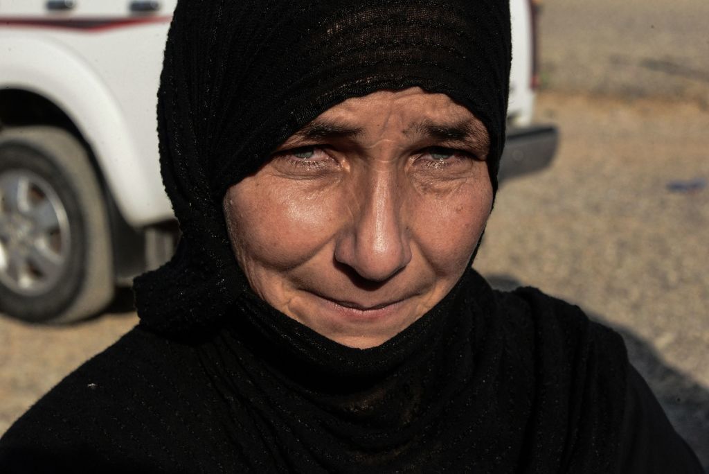 A displaced Iraqi woman prepares to board a bus at a camp for displaced people in Hammam al-Alil, south of the northern Iraqi city of Mosul, on August 27, 2019, as they are transferred back to Kirkuk province. - Hundreds of displaced Iraqis, mostly women and children, were transferred from a northern camp to their home areas despite humanitarian concerns over what awaits them on their return. The civilians originally hailed from Hawija but had fled fighting against the Islamic State group years ago to Hamma