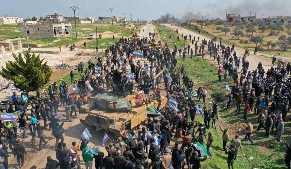 Syrians in protest climb atop a Turkish military M60T tank and infantry-fighting vehicle (IFV) as they attempt to block traffic on the M4 highway, which links the northern Syrian provinces of Aleppo and Latakia, before incoming joint Turkish and Russian military patrols (as per an earlier agreed upon ceasefire deal) in the village of al-Nayrab, about 14 kilometres southeast of the city of Idlib and seven kilometres west of Saraqib in northwestern Syria on March 15, 2020