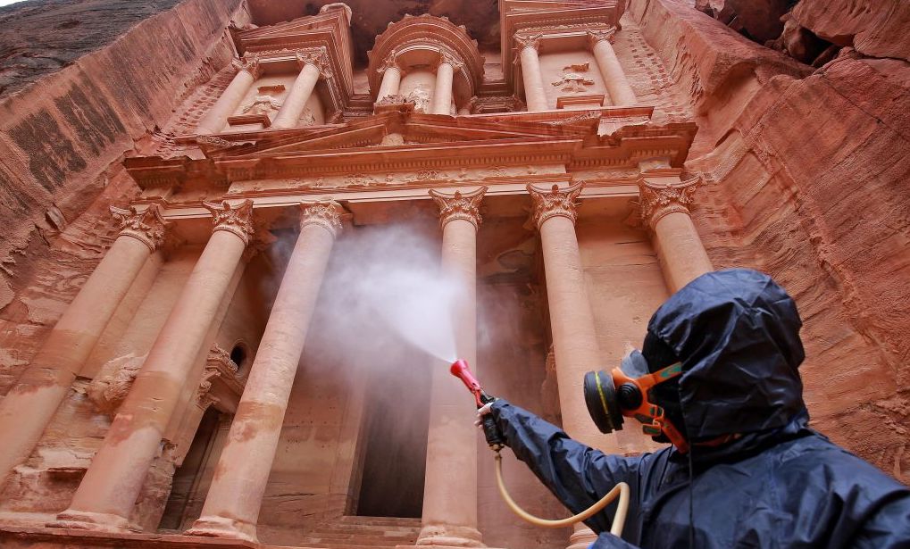 A labourer sprays disinfectant in Jordan's archaeological city of Petra south of the capital Amman on March 17, 2020, to prevent the spread of COVID-19. 