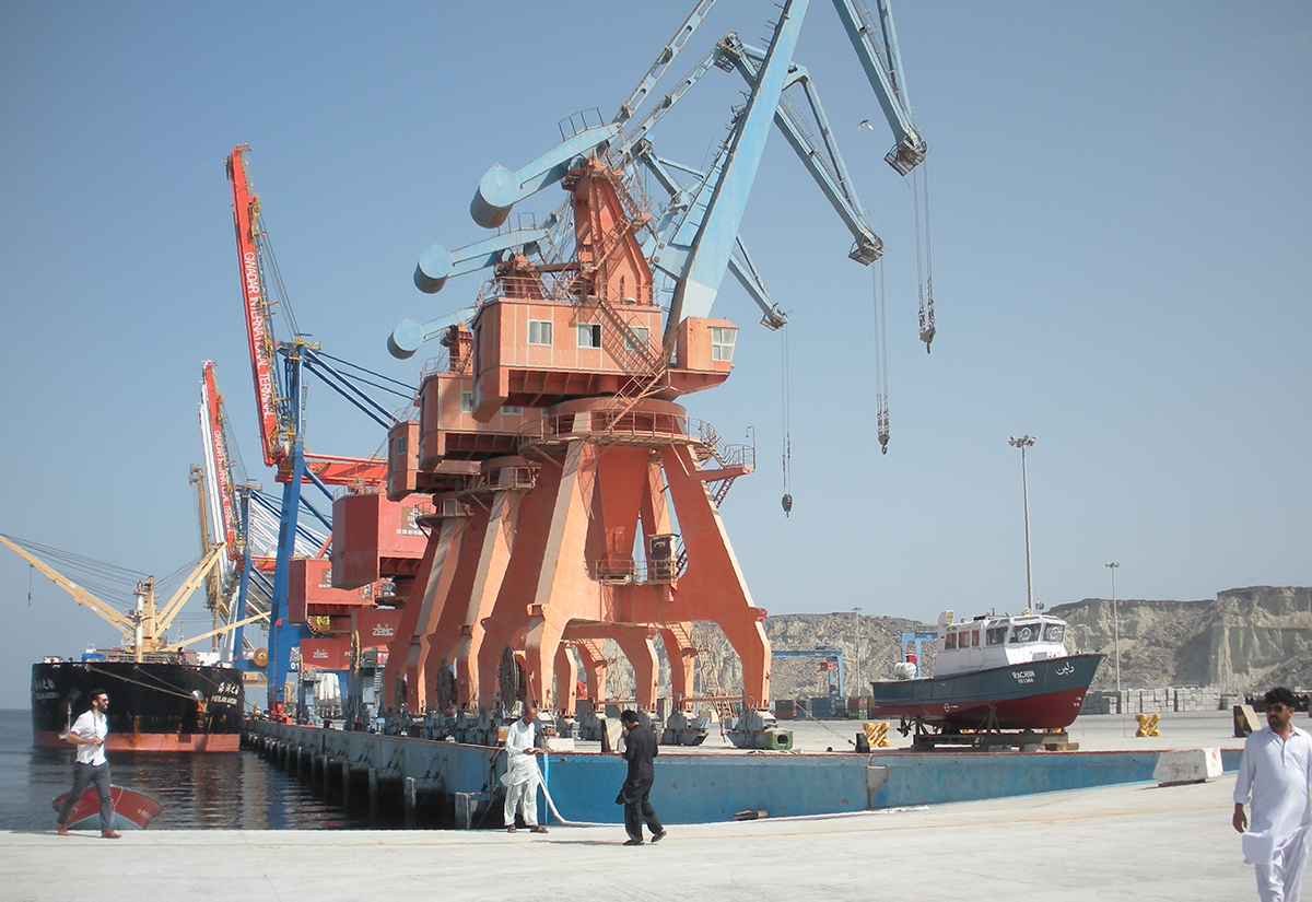 In this photograph taken on October 4, 2017, Pakistani labourers walk through Gwadar port. Remote and impoverished, Pakistan's Gwadar port at first glance seems an unlikely crown jewel in a multi-billion dollar development project with China aimed at constructing a 21st century Silk Road. Situated on a barren peninsula in the Arabian Sea, Gwadar, or the 